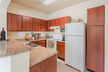 A kitchen with white appliances and granite counter tops